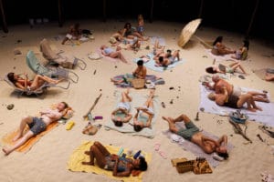 Performers on the beach in Sun & Sea performed at the Albany in Deptford